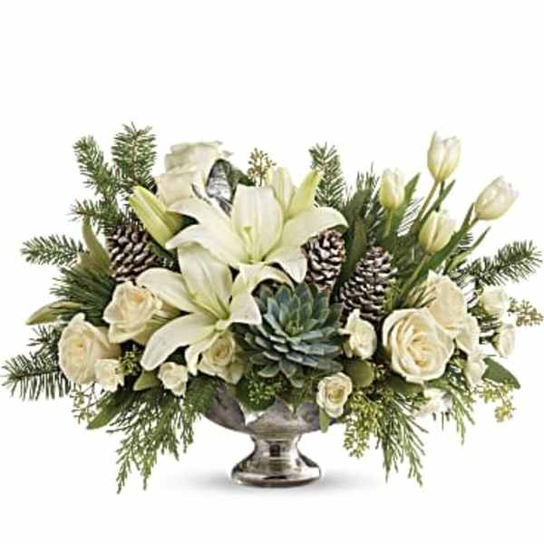 White lilies and roses arranged in a silver pedestal bowl