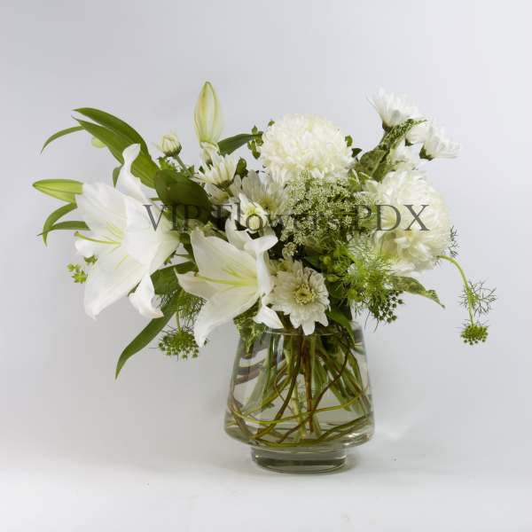 White lilies and chrysanthemums in a clear glass vase