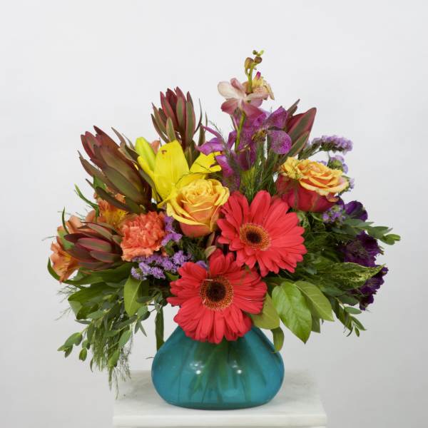 Colorful mixed bouquet in a turquoise glass vase