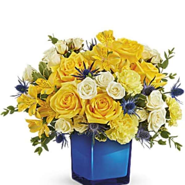 Yellow and white rose bouquet in a blue glass vase