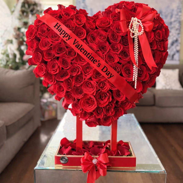 Heart-shaped red rose arrangement with a Valentine’s Day ribbon