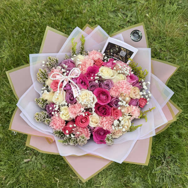 Large bouquet of pink, cream, and purple roses with carnations