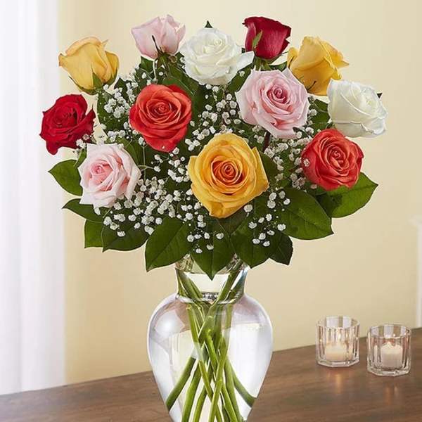 Mixed roses in a clear glass vase with baby's breath