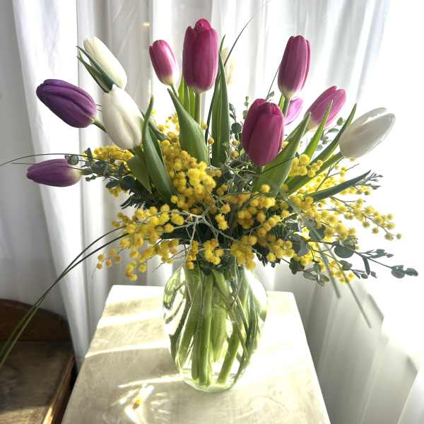 Bouquet of purple, pink, and white tulips in a glass vase