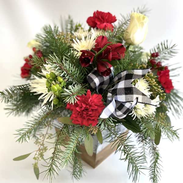 Holiday bouquet with red and white flowers in a box, tied with a plaid ribbon