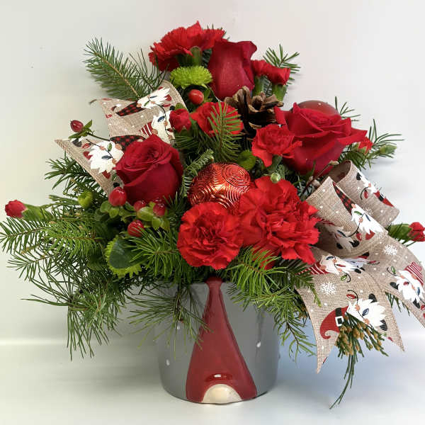 Red roses and carnations in a gray vase with holiday ribbon