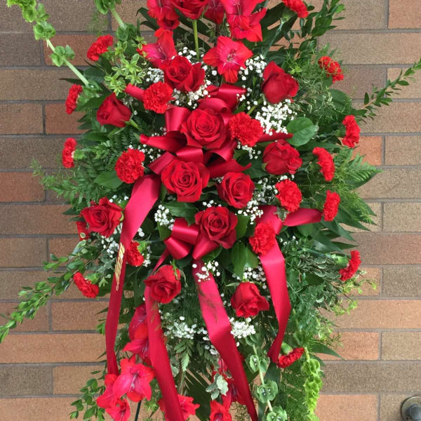 Tall red floral standing spray with roses and ribbons