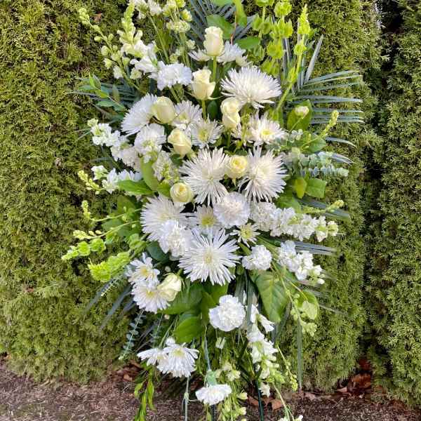Tall white floral standing spray on a metal easel