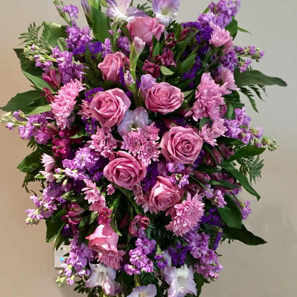 Large standing spray of pink and purple flowers on an easel