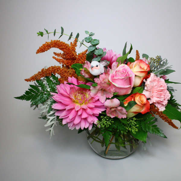 Pink and peach flower arrangement in a clear glass vase