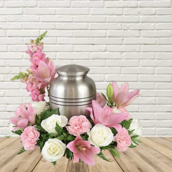Pink and white floral arrangement around a silver urn