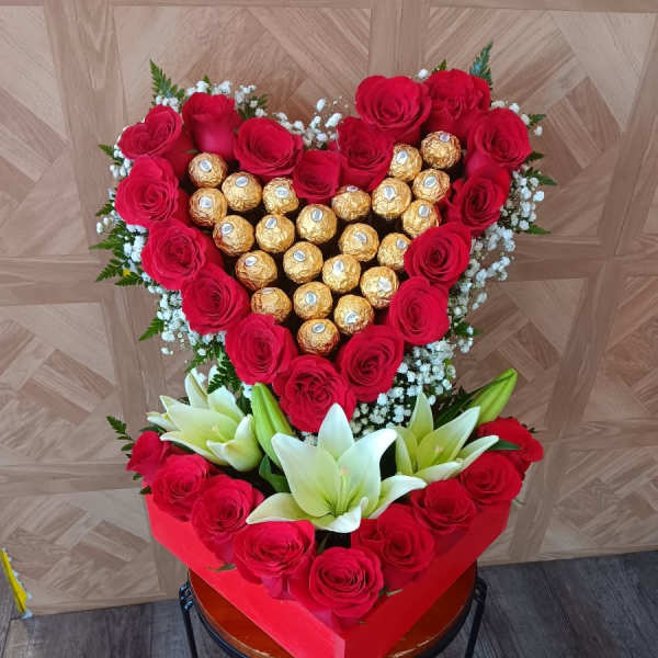Heart-shaped rose and chocolate arrangement with white lilies