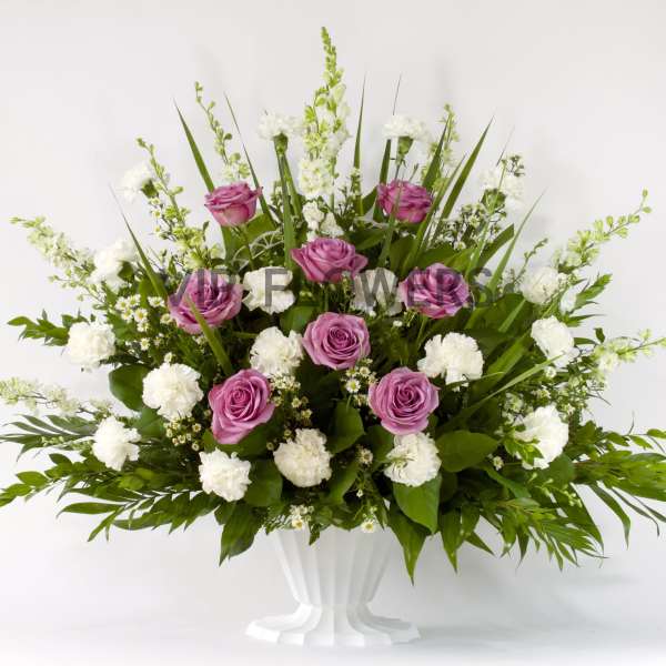Pink roses and white carnations in a white vase