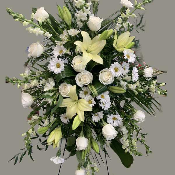 White lilies, roses, and daisies in a large standing spray