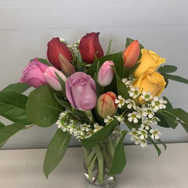 Mixed roses and tulips in a clear glass vase