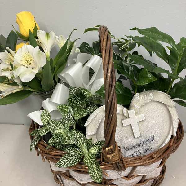 Basket arrangement with yellow and white flowers and a memorial plaque