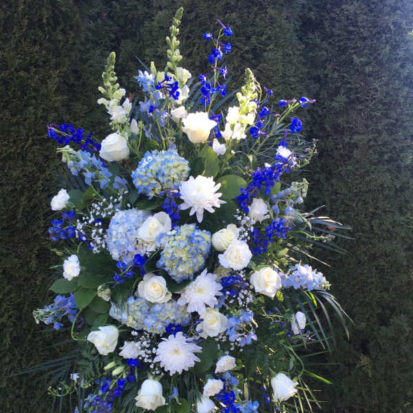 Tall blue and white floral standing spray with roses and hydrangeas