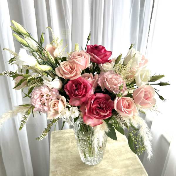 Pink and white rose bouquet in a clear glass vase