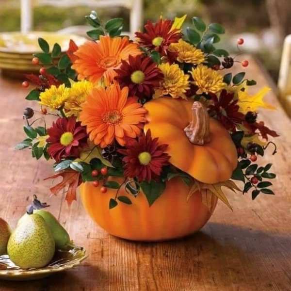 Pumpkin centerpiece with orange and burgundy flowers