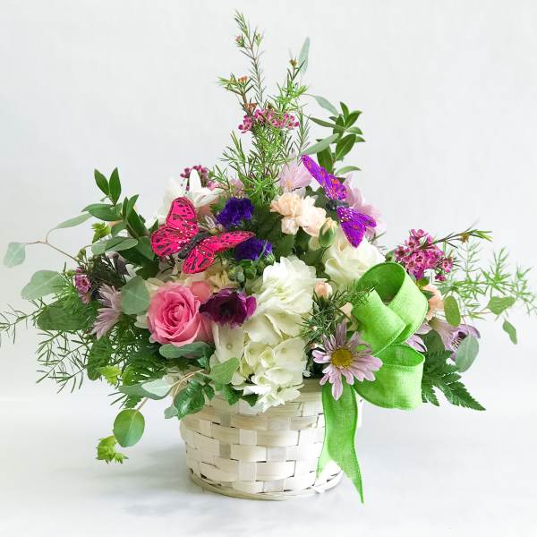 Mixed flower basket with pink and white blooms and butterfly accents