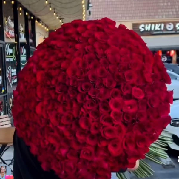 Large round bouquet of red roses held outdoors
