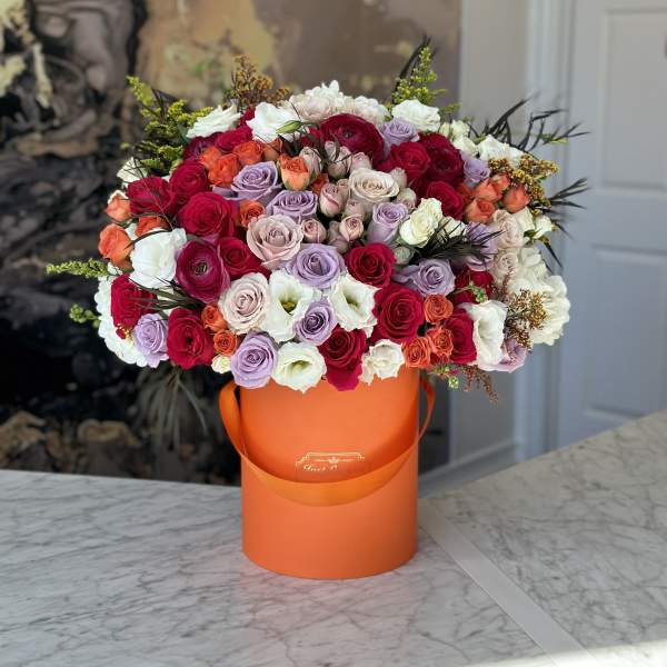 Large mixed rose bouquet in an orange hatbox