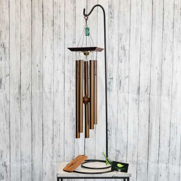 Copper wind chime hanging from a black stand