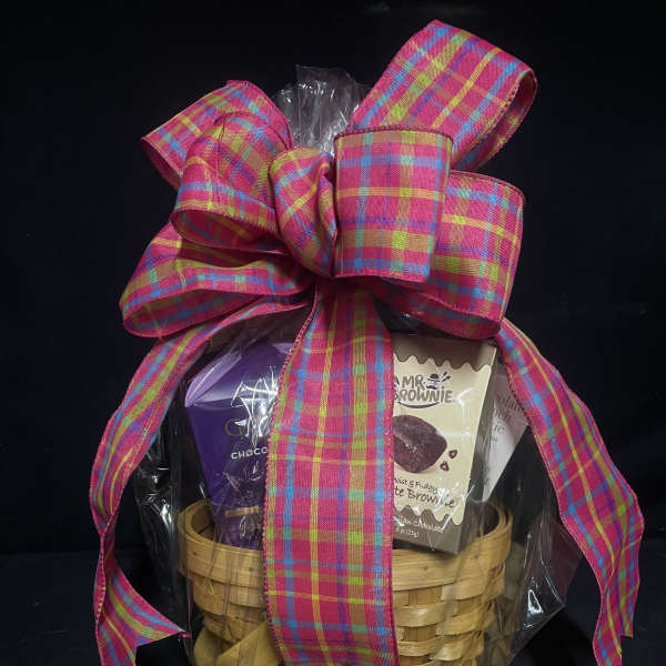 Gift basket with chocolates and brownies tied with a large plaid ribbon