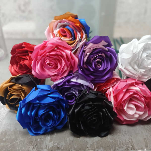 Assorted satin ribbon roses in multiple colors arranged in a cluster