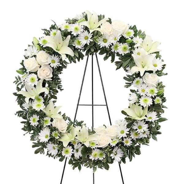 White floral wreath on a black easel stand