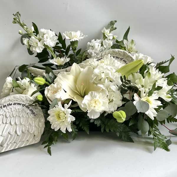 White sympathy floral arrangement with an angel wing plaque