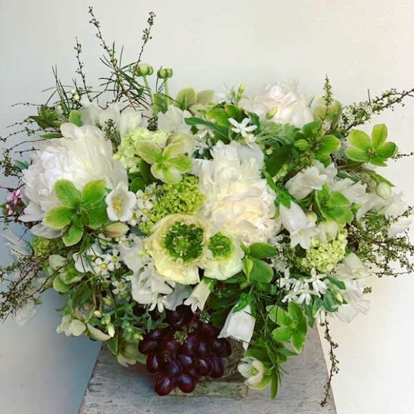 White and green floral arrangement in a low container