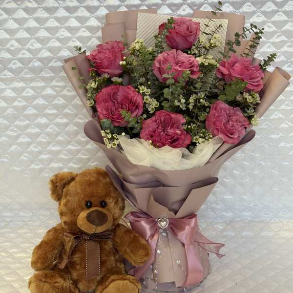 Pink rose bouquet with a teddy bear and satin ribbon
