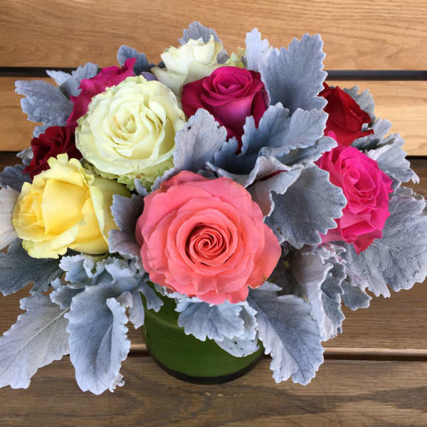 Bouquet of multicolored roses in a green vase