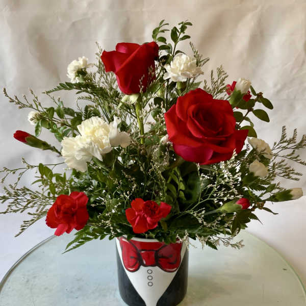 Red roses and white carnations in a tuxedo-themed vase