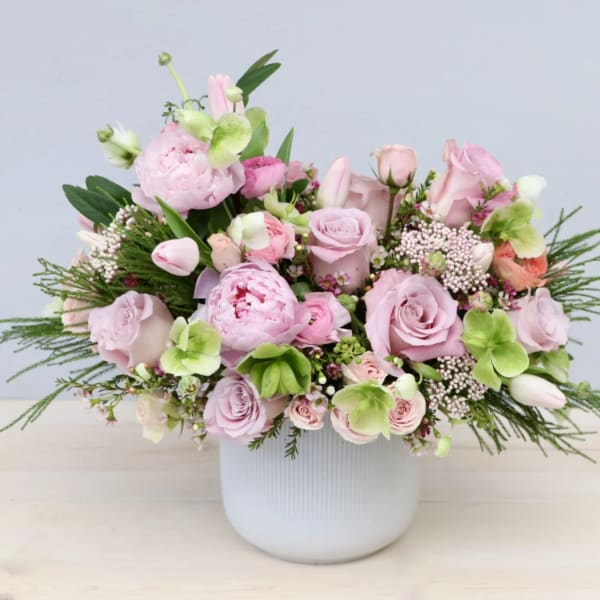 Pink and green floral arrangement in a white vase