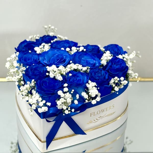 Blue roses with white baby's breath in a round white box