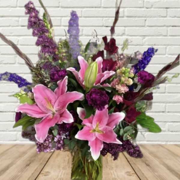 Bouquet of pink lilies and purple flowers in a hand-tied arrangement