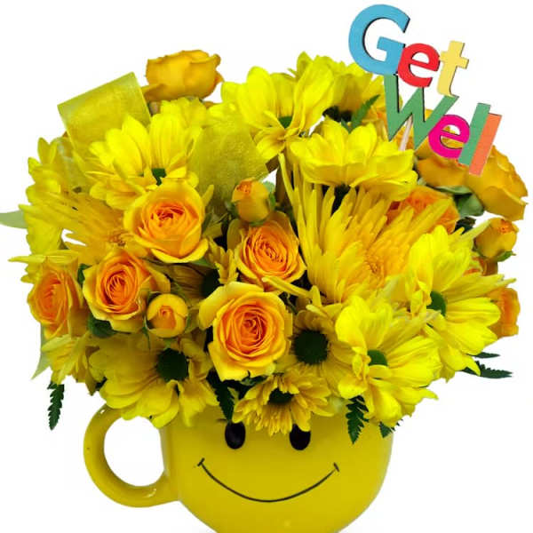 Yellow roses and daisies in a yellow smiley-face mug with a colorful Get Well pick
