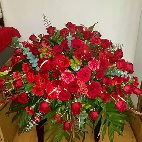 Large arrangement of red roses and carnations with greenery