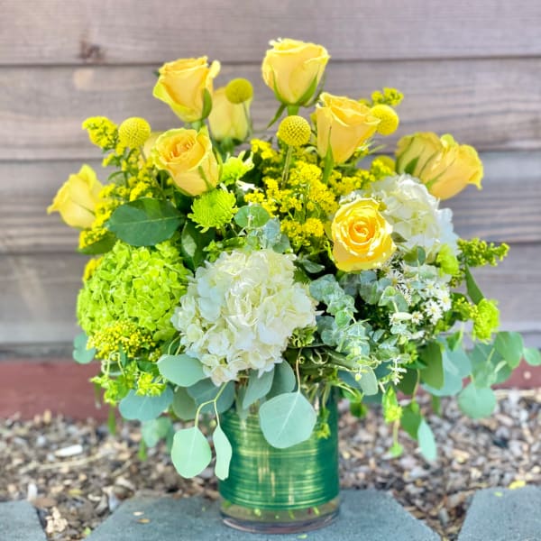 Yellow roses and white hydrangeas in a glass vase