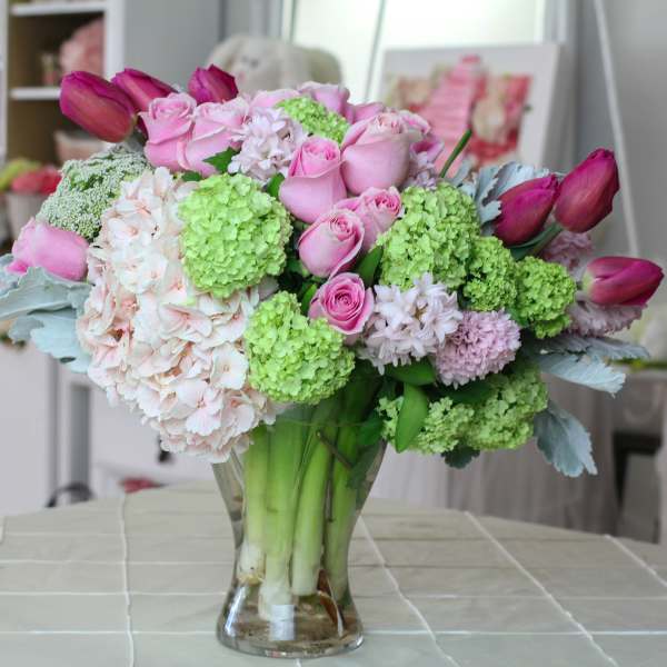 Pink roses and green hydrangeas in a clear glass vase