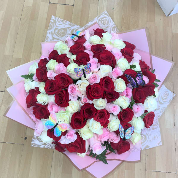 Large bouquet of red, pink, and white roses with butterfly decorations