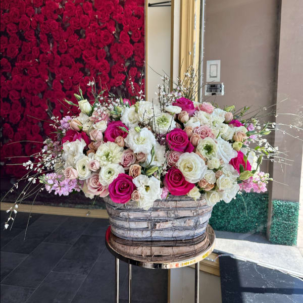 Large mixed rose arrangement in a woven basket on a stand