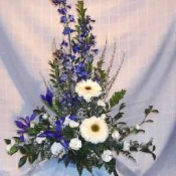Tall blue and white flower arrangement with layered blooms in a fan shape