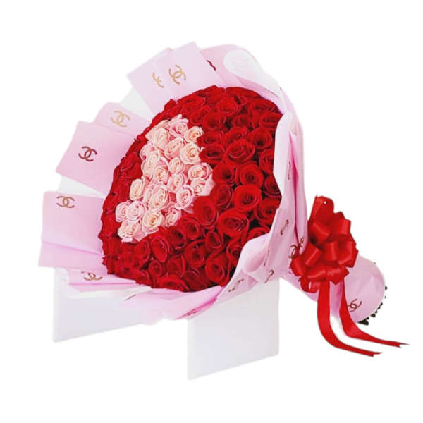 Large bouquet of red and pink roses arranged in a heart pattern with pink wrapping paper