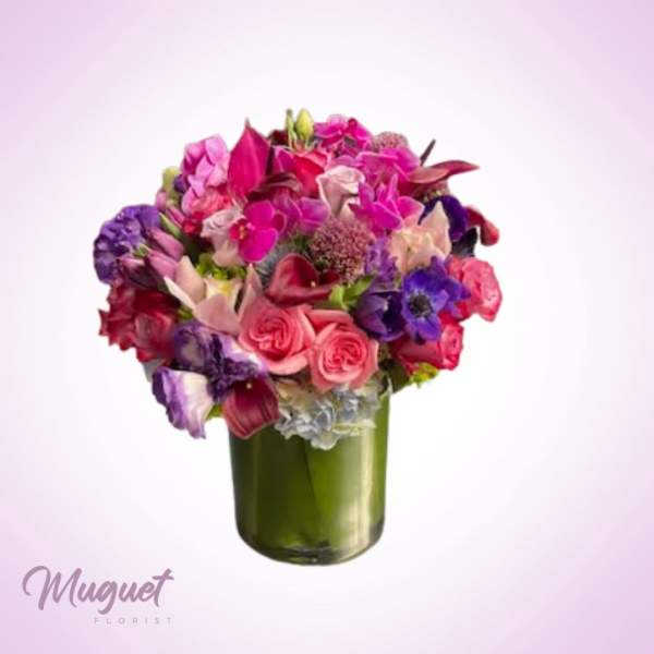 Mixed pink and purple bouquet in a green glass vase
