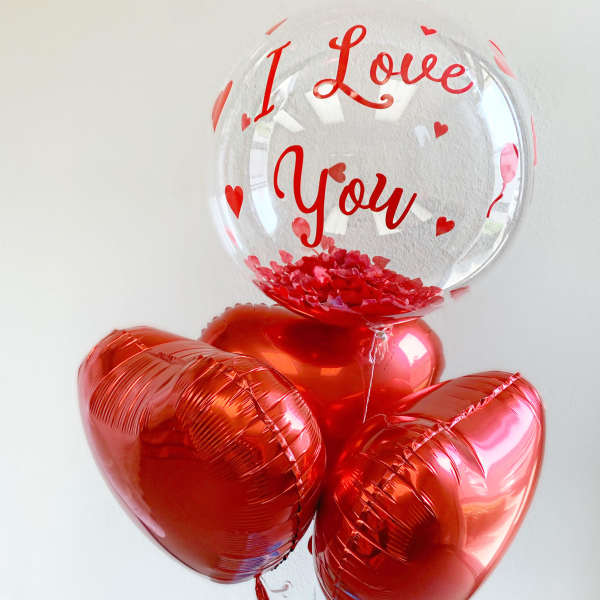 Heart-shaped balloons with a clear balloon reading "I Love You"