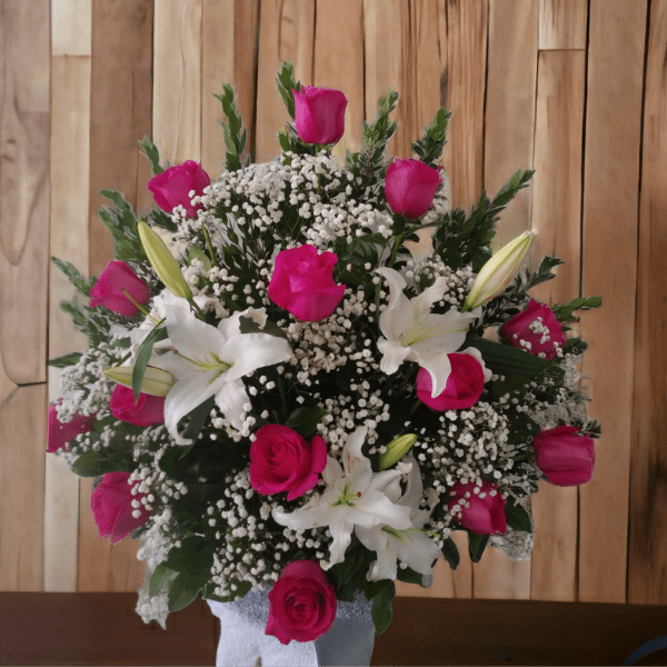 Pink roses and white lilies in a vase with baby's breath