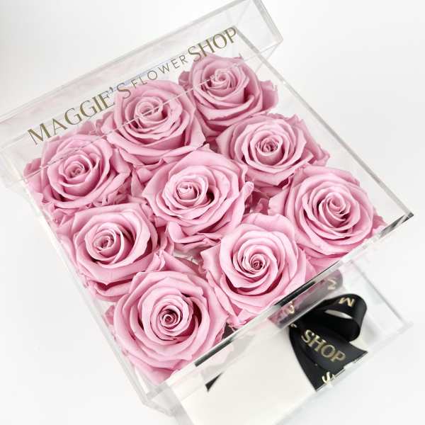 Box of pink roses in a clear gift box with a ribbon